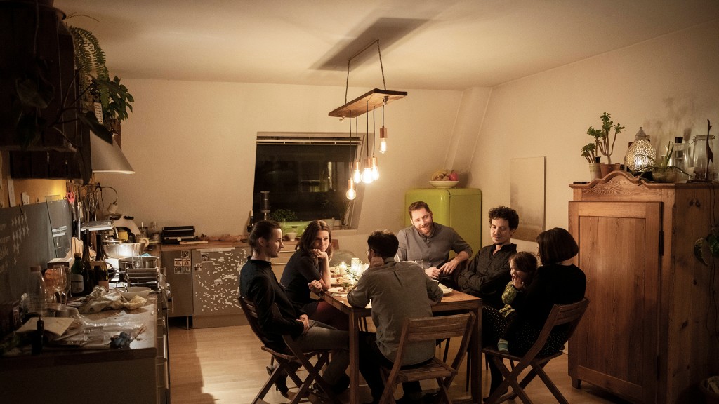 Menschen sitzen um einen Küchentisch herum (Foto: IMAGO / Westend61)