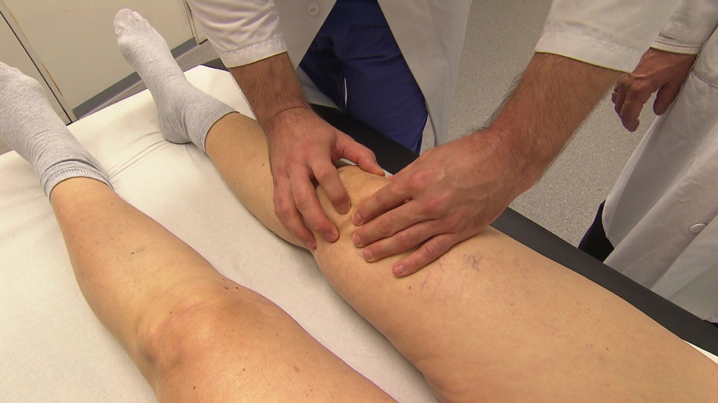 Arzt kontrolliert ein liegendes Knie