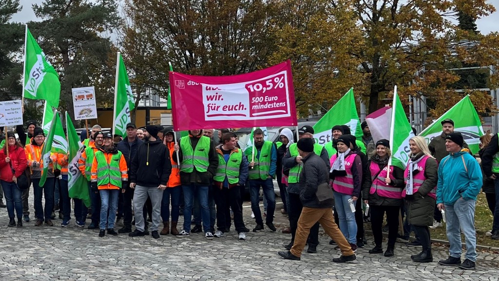 Foto: Streikteilnehmer mit Warnwesten und Fahnen