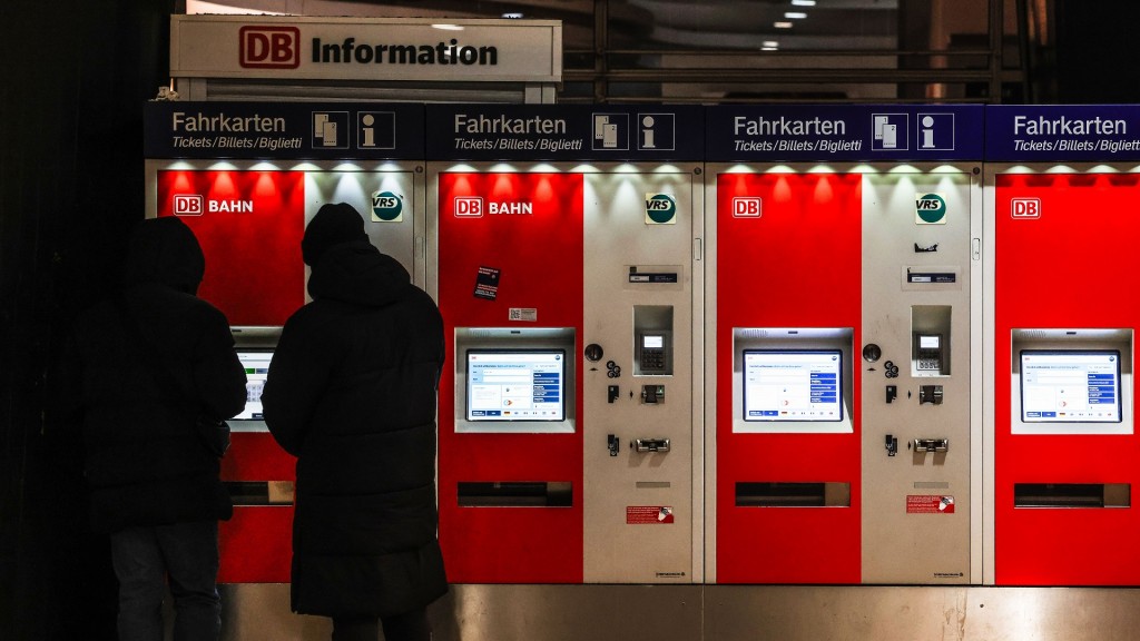 Foto: Fahrgäste stehen an einem Fahrkartenauromat.