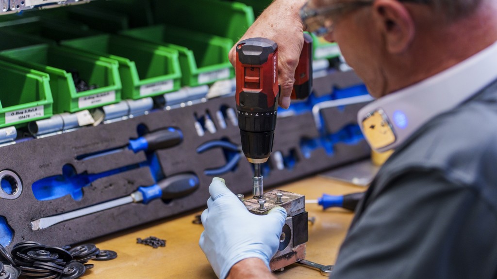 Foto: Ein Mitarbeiter schraubt in der Montage eines Industriebetriebes