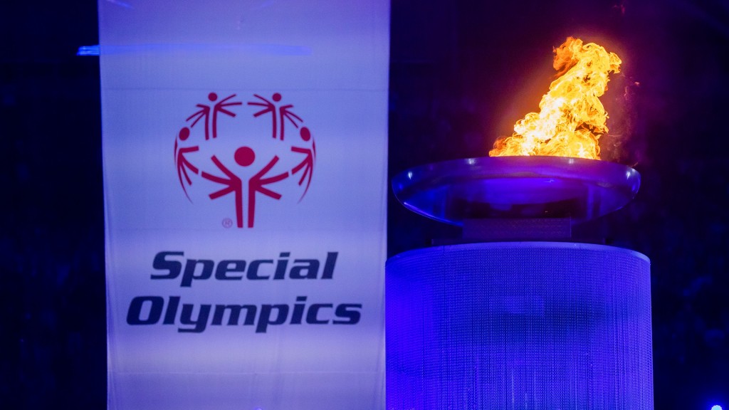 Das Logo der Special Olympics auf einer Fahne neben der olympischen Flamme.