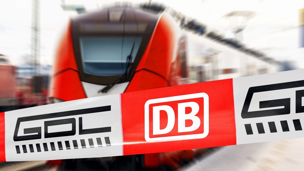 Foto: Absperrband mit Logo von DB (Deutsche Bahn) und GDL (Gewerkschaft Deutscher Lokomotivführe) vor einem Zug am Bahnhof.