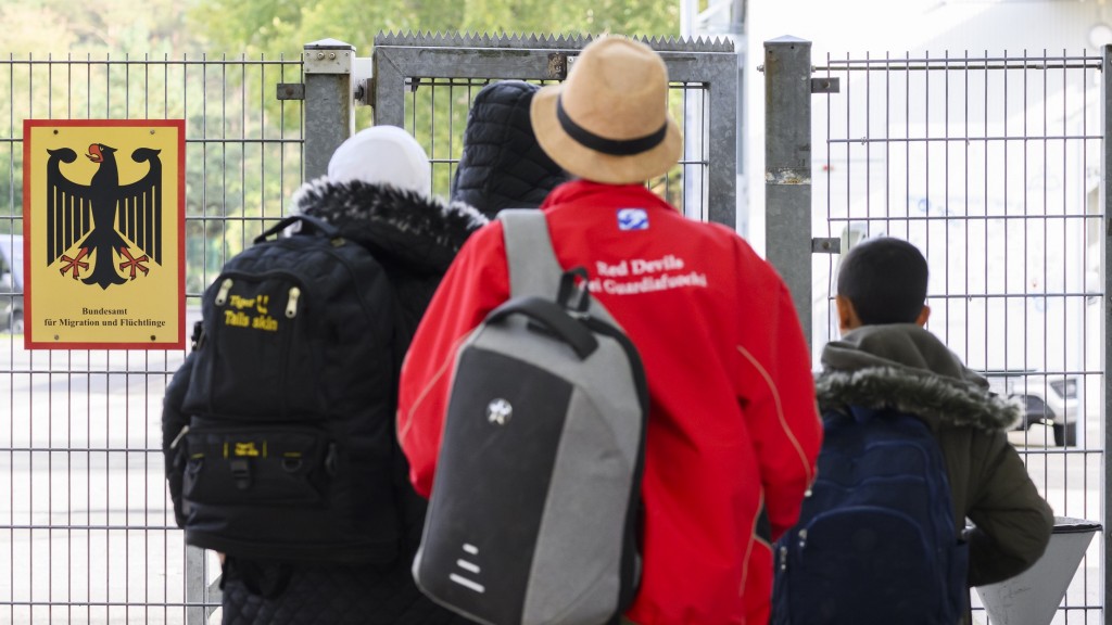 Geflüchtete stehen vor dem Tor des Bundesamtes für Migration