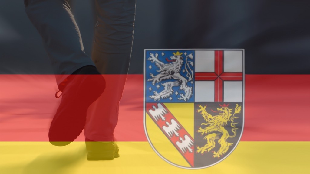 Foto: Symbolbild Bevölkerungsrückgang im Saarland. Saarlandflagge mit einer Person, die den Raum verlässt.