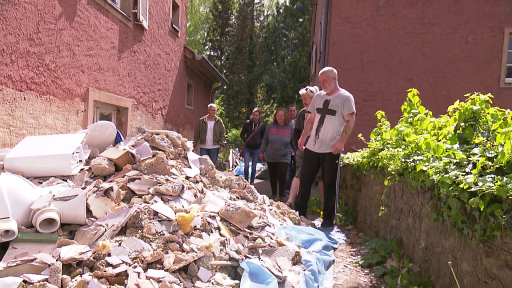 Foto: Mieterinnen und Mieter der Wohnsiedlung vor Bauschutt