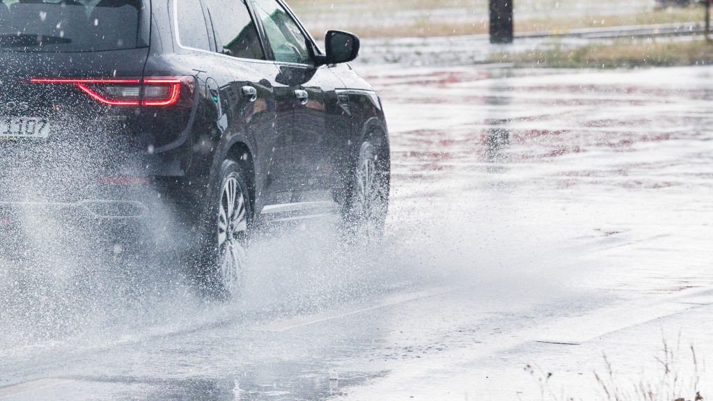 Symbolbild: Ein Auto fährt bei Starkregen über eine Straße.