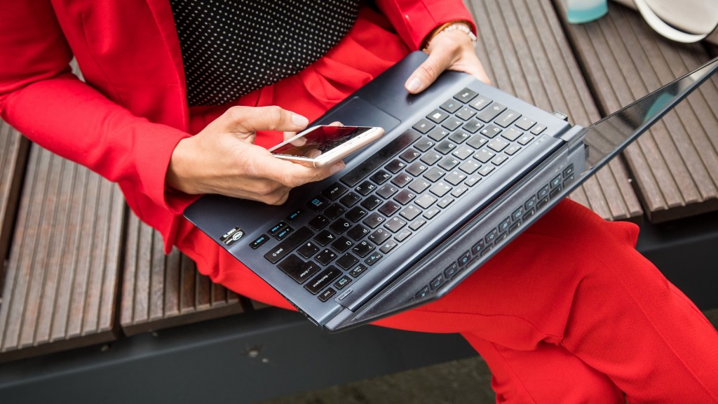 Symbolbild: Eine berufstätige Frau mit Laptop und Smartphone