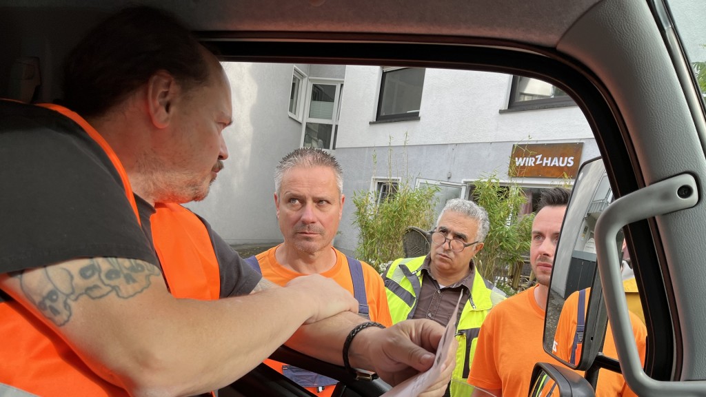 Müllwerker unterhalten sich bei der Arbeit