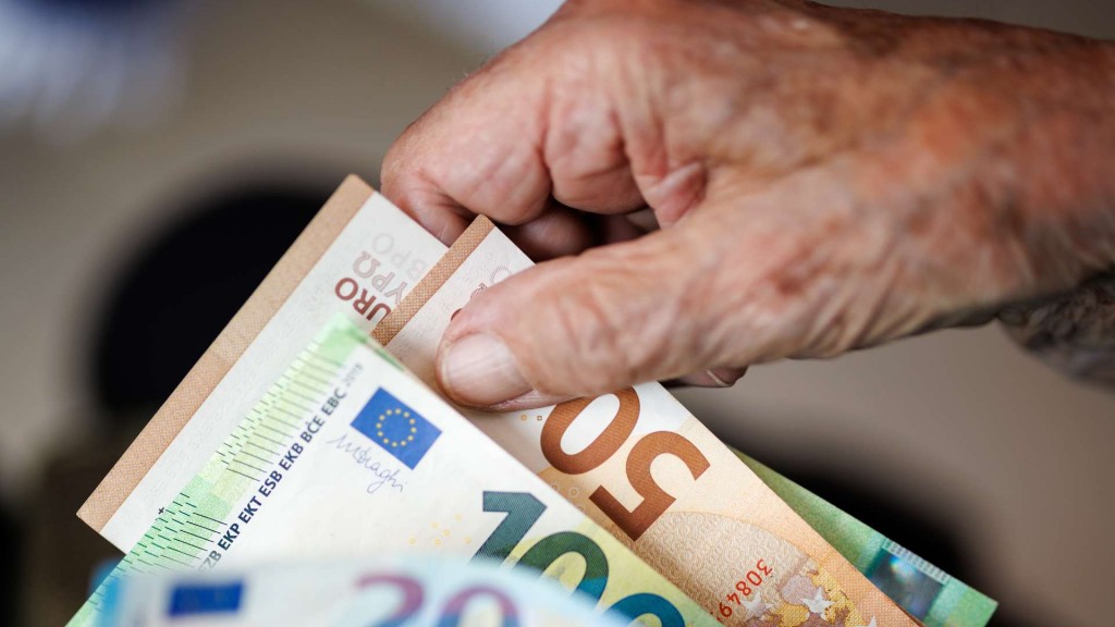 Eine ältere Person hält mehrere Geldscheine in den Händen
