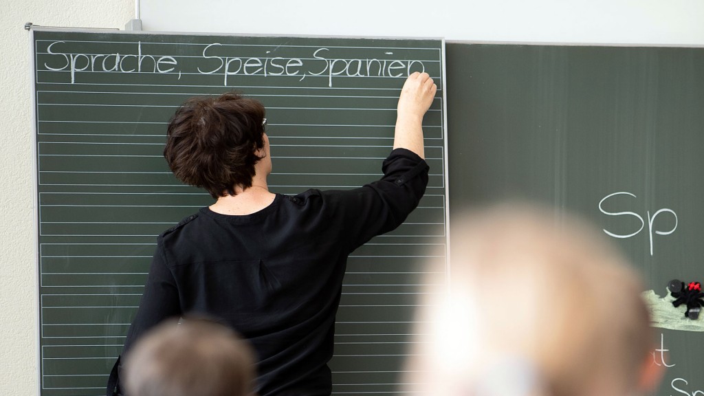 Eine Lehrerin schreibt Worte an eine Tafel