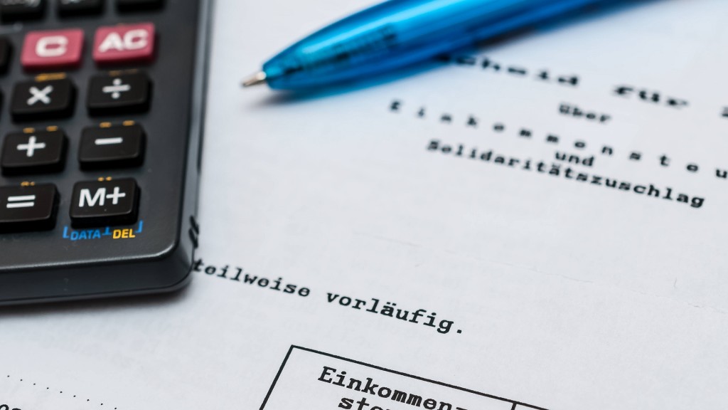 Ein Stift und ein Taschenrechner liegen auf dem Steuerbescheid des Finanzamtes