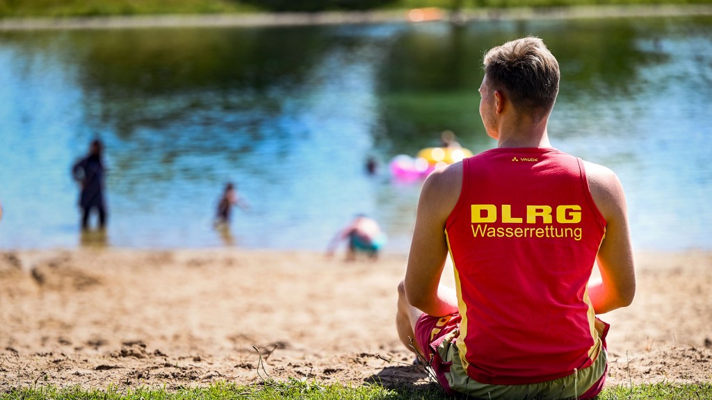 Ein Rettungsschwimmer des DLRG überwacht einen Badestrand am See