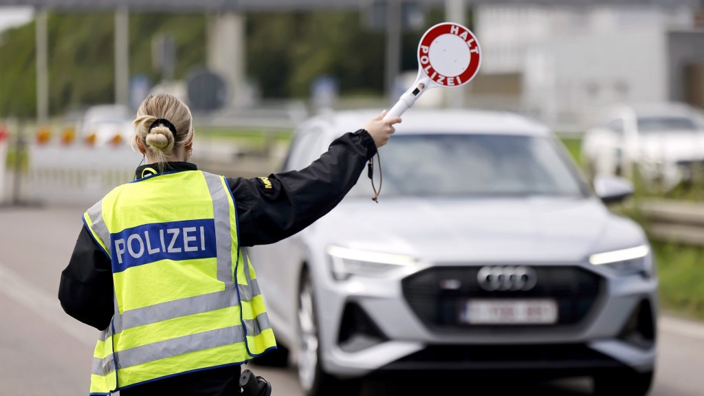 Foto: Polizisten kontrollieren Fahrzeuginsassen und Papiere bei der Einreise nach Deutschland