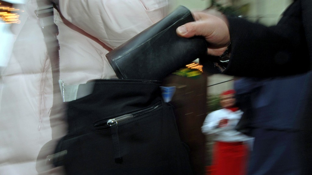 Eine Person zieht eine Geldbörse aus einer Handtasche