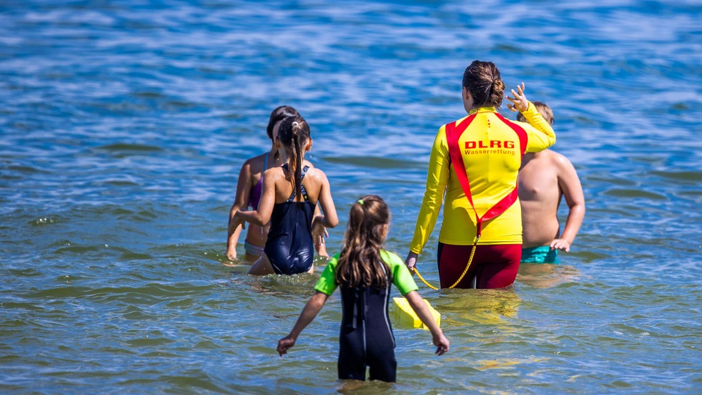 Eine Rettungsschwimmerin der DLRG zwischen Kindern in einem Badesee