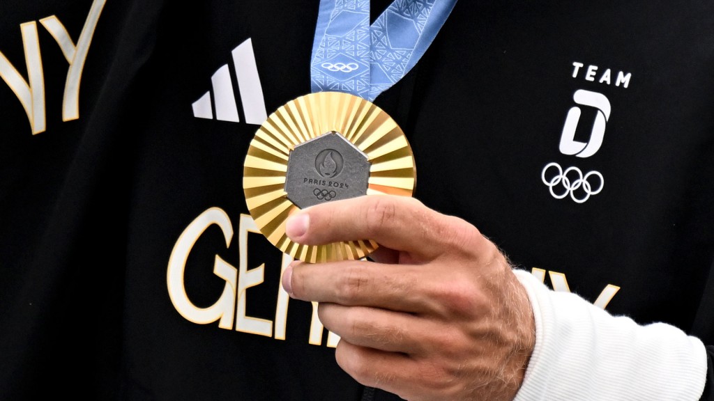 Ein Sportler des deutschen Olympia-Teams präsentiert seine Goldmedaille der olympischen Spiele Paris 2024