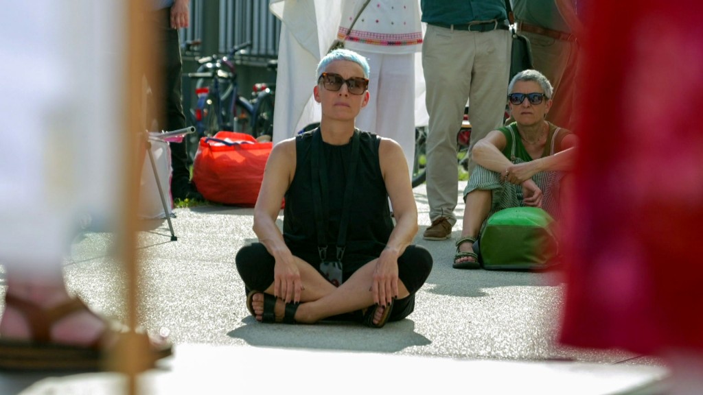 Candice Breitz protestiert sitzend vor dem Saarlandmuseum