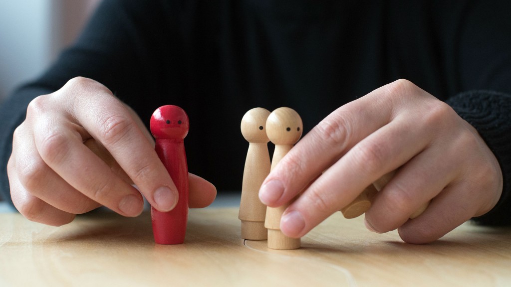 Ein Patient erklärt sich während einer Therapie mit kleinen Holzfiguren auf dem Tisch