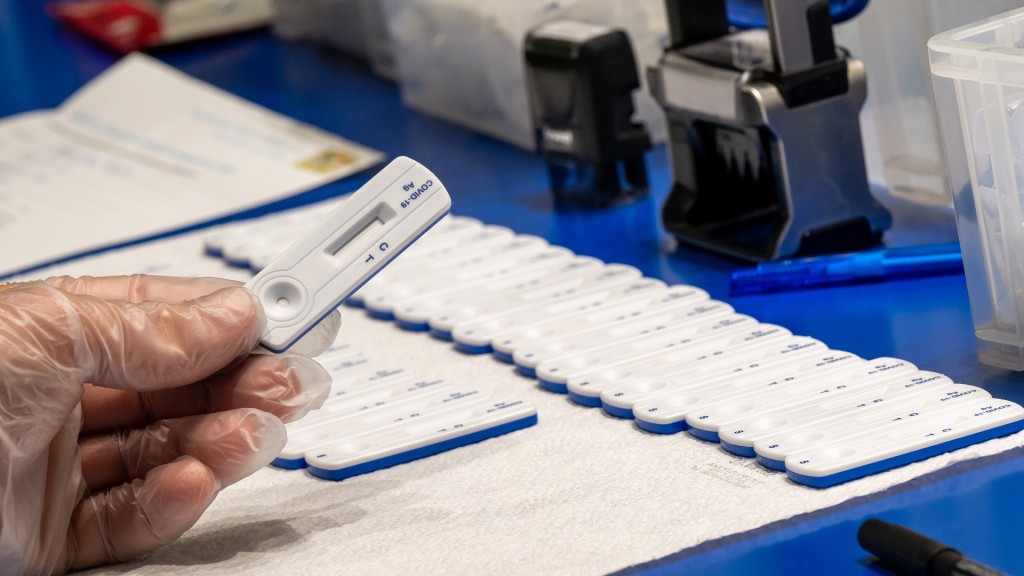 Foto: Ein Mitarbeiter einer Apotheke hält einen noch unbenutzten Corona-Schnelltest in der Hand