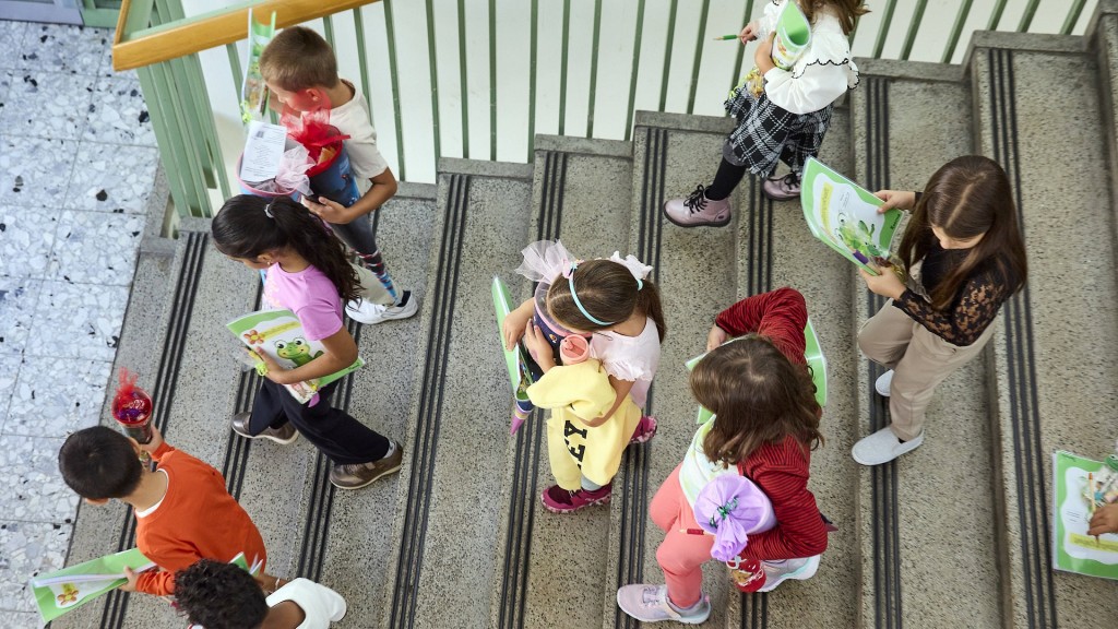 Kinder laufen die Treppe einer Schule hinunter