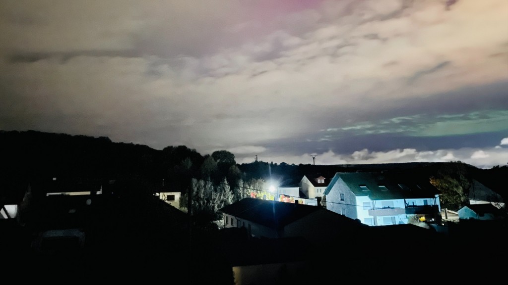 Polarlichter an einem wolkenbedeckten Himmel über Überherrn, sichtbargemacht mit Hilfe einer Kamera.