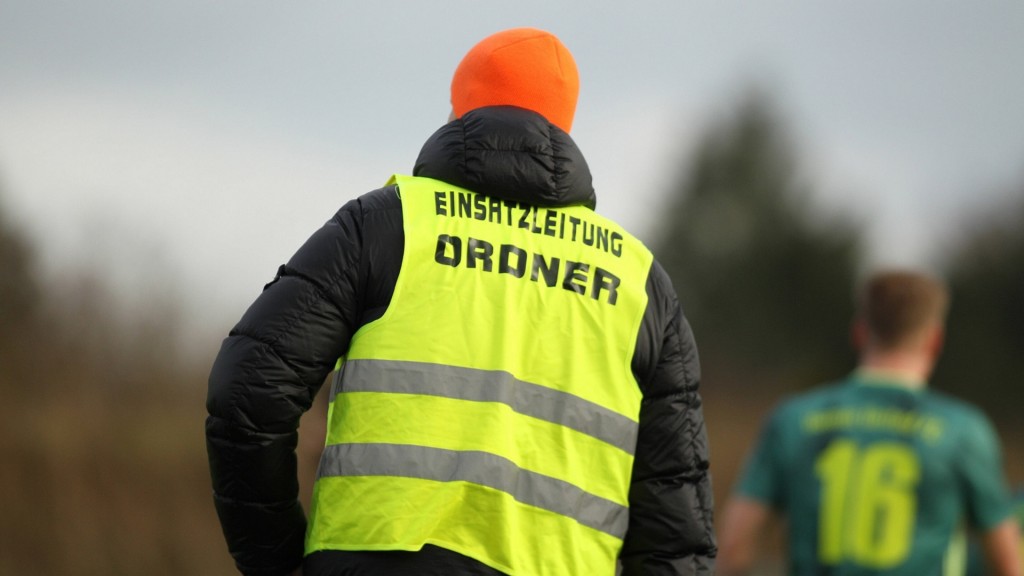 Ein Ordner am Rande eine Spieles im Amateurfussball.