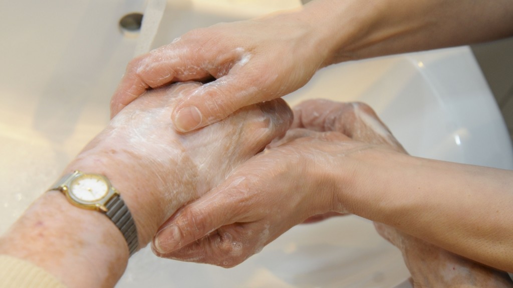 Eine Pflegerin hilft einer Frau bei der Handwäsche.