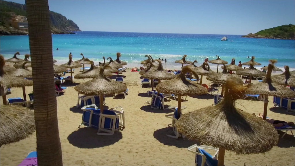 Strand mit Sonnenliegen und Sonnenschirmen