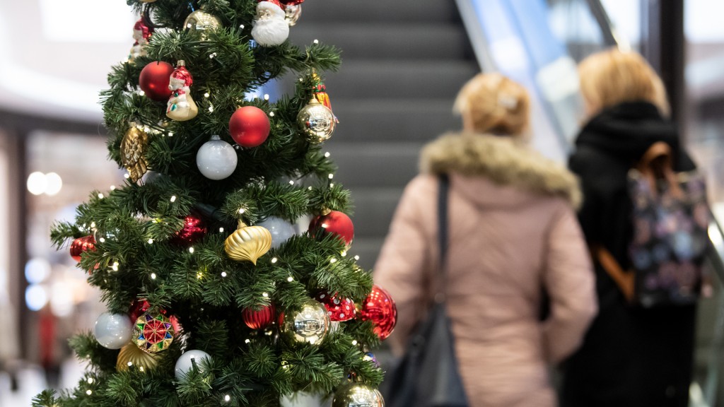 Kunden gehen in einem Einkaufszentrum an einer Weihnachts-Dekoration vorbei