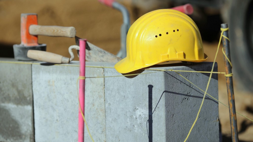 Ein gelber Bauarbeiterhelm liegt auf einem Mauerwerk auf einer Baustelle