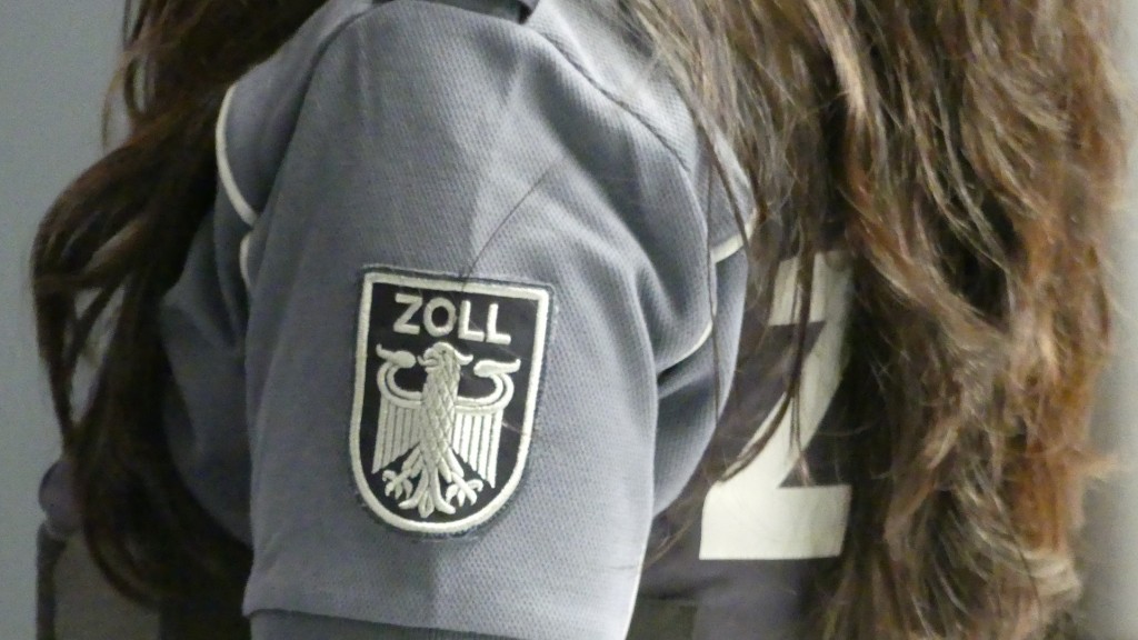 Foto: Emblem des Zolls auf der Uniform einer Zollbeamtin