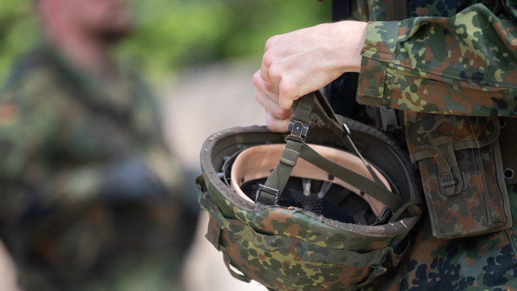 Ein Soldat hält seinen Helm in der Hand