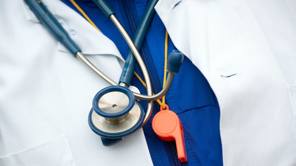 Ein Arzt trägt ein Sthetoskop und eine Trillerpfeife um den Hals