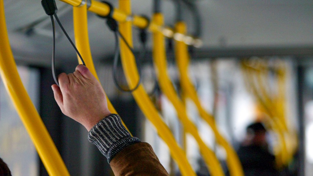 Ein Fahrgast hält sich im Bus an einer Halteschlaufe fest