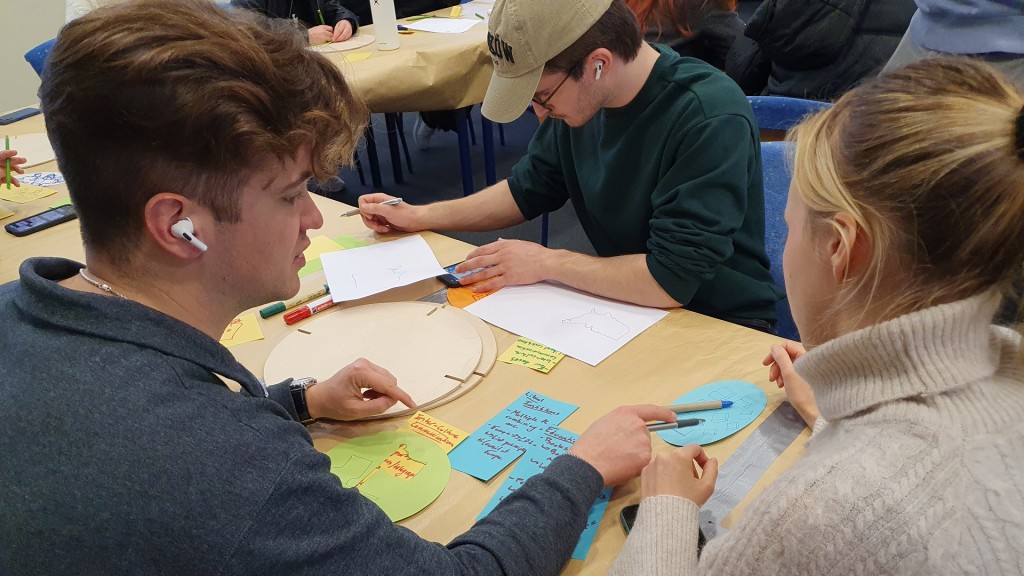 Internationale Studierende beschriften Holztafel und Plakate in Otzenhausen