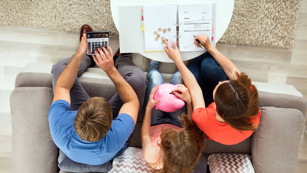 Eltern sitzen mit ihrem Kind auf der Couch und zählen Spargeld