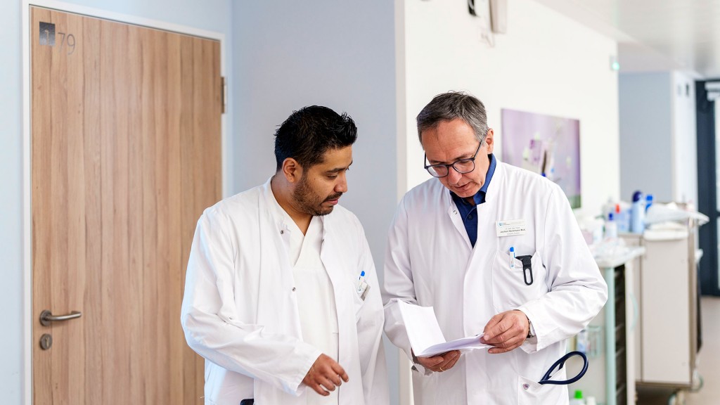 Foto: Zwei Ärzte besprechen sich in einem Krankenhausflur