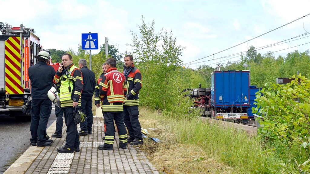 Foto: Einsatzkräfte stehen an der Unfallstelle am Saarbahn-Halt „Heinrichshaus“, wo ein Lkw verunfallt auf den Gleisen liegt