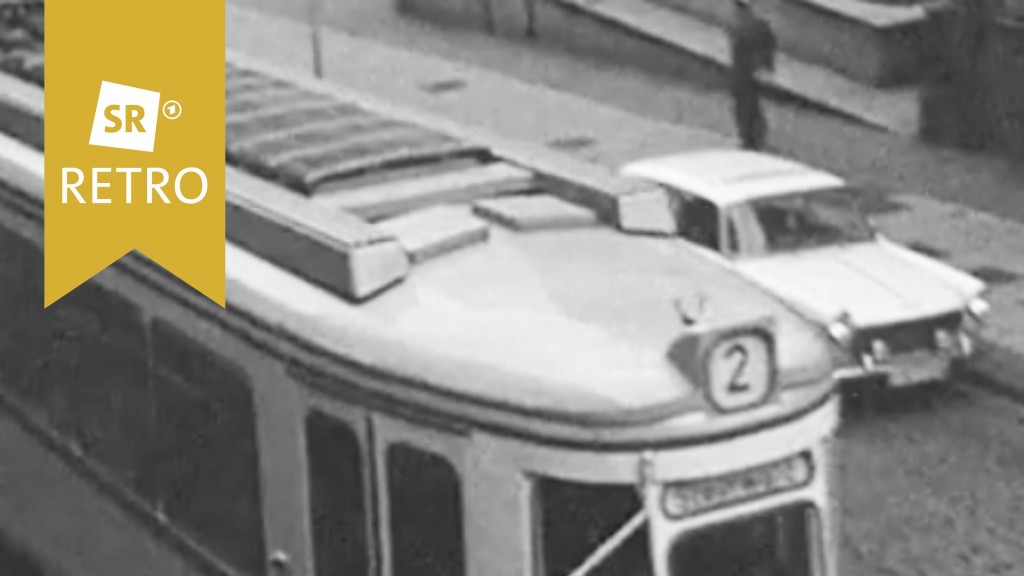 Straßenbahn aus den 50er Jahren. Daneben fährt ein Auto.
