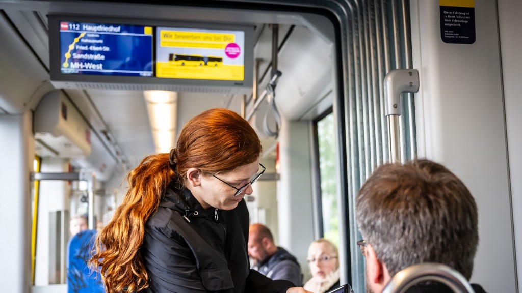 Foto: Fahrscheinkontrolle. Eine Kontrolleurin bei der Arbeit.