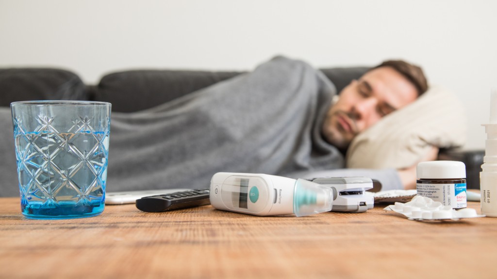 Ein Mann liegt krank auf einem Sofa