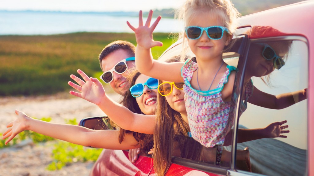 Familie winkt aus einem Auto