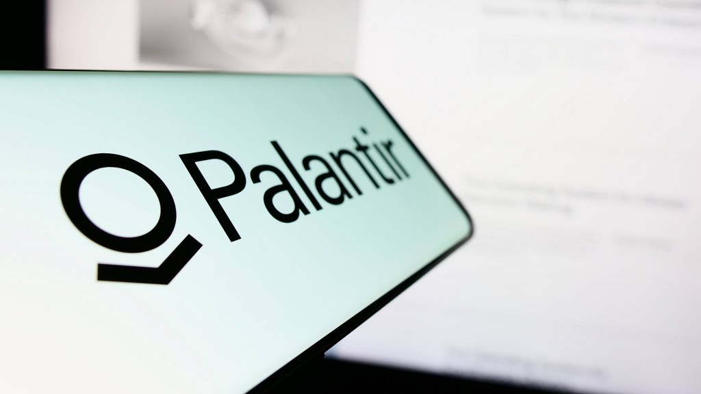 Ein Handy auf dem Palantir zu lesen ist - im Hintergrund ein Computerbildschirm.