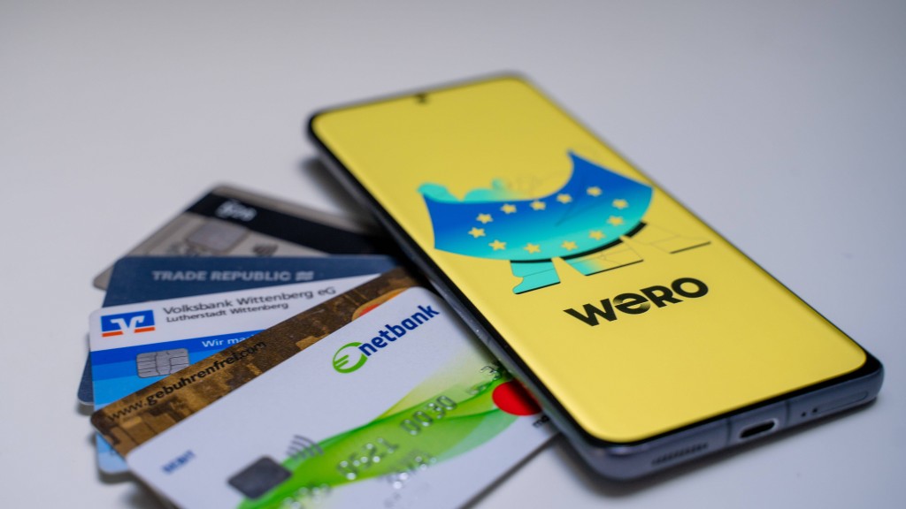 Handy mit geöffneter Wero App und Bankkarten daneben