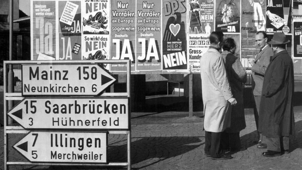 Passanten diskutieren 1955 vor einer Anschlagtafel über die bevorstehende Saarabstimmung
