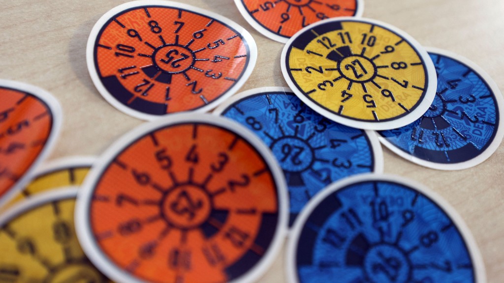 Tüv-Plaketten verschiedener Gültigkeit liegen auf einem Tisch