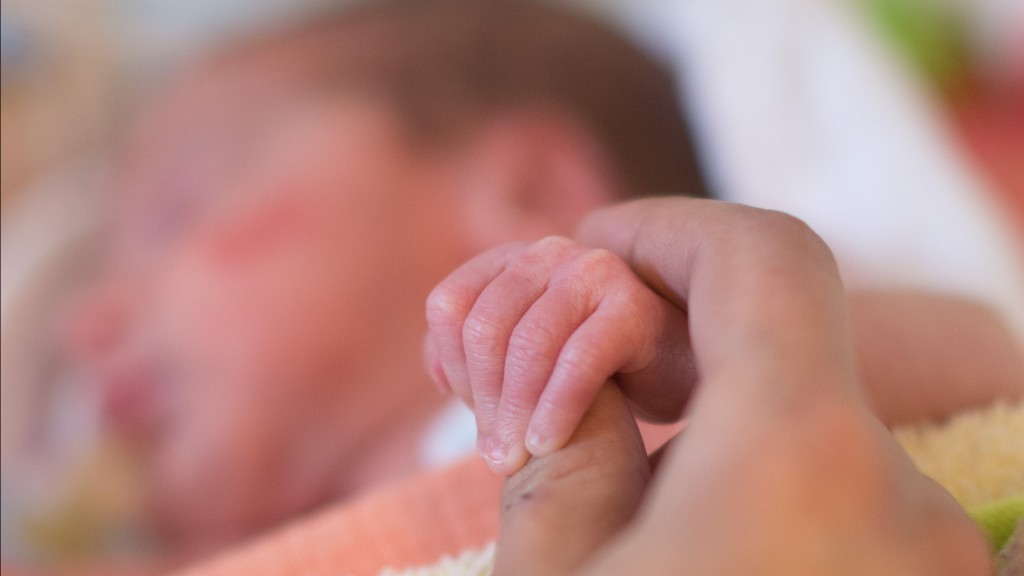 Eine Frau hält Hand eines Neugeborenen