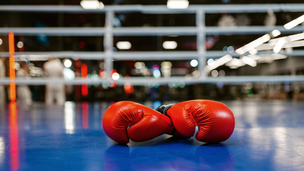 Rote Boxhandschuhe liegen in einem blauen Boxring