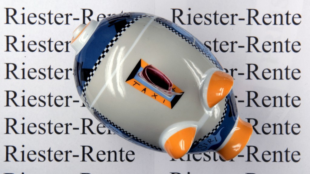 Ein Sparschwein steht auf einem Werbeträger mit der Aufschrift Riesterrente